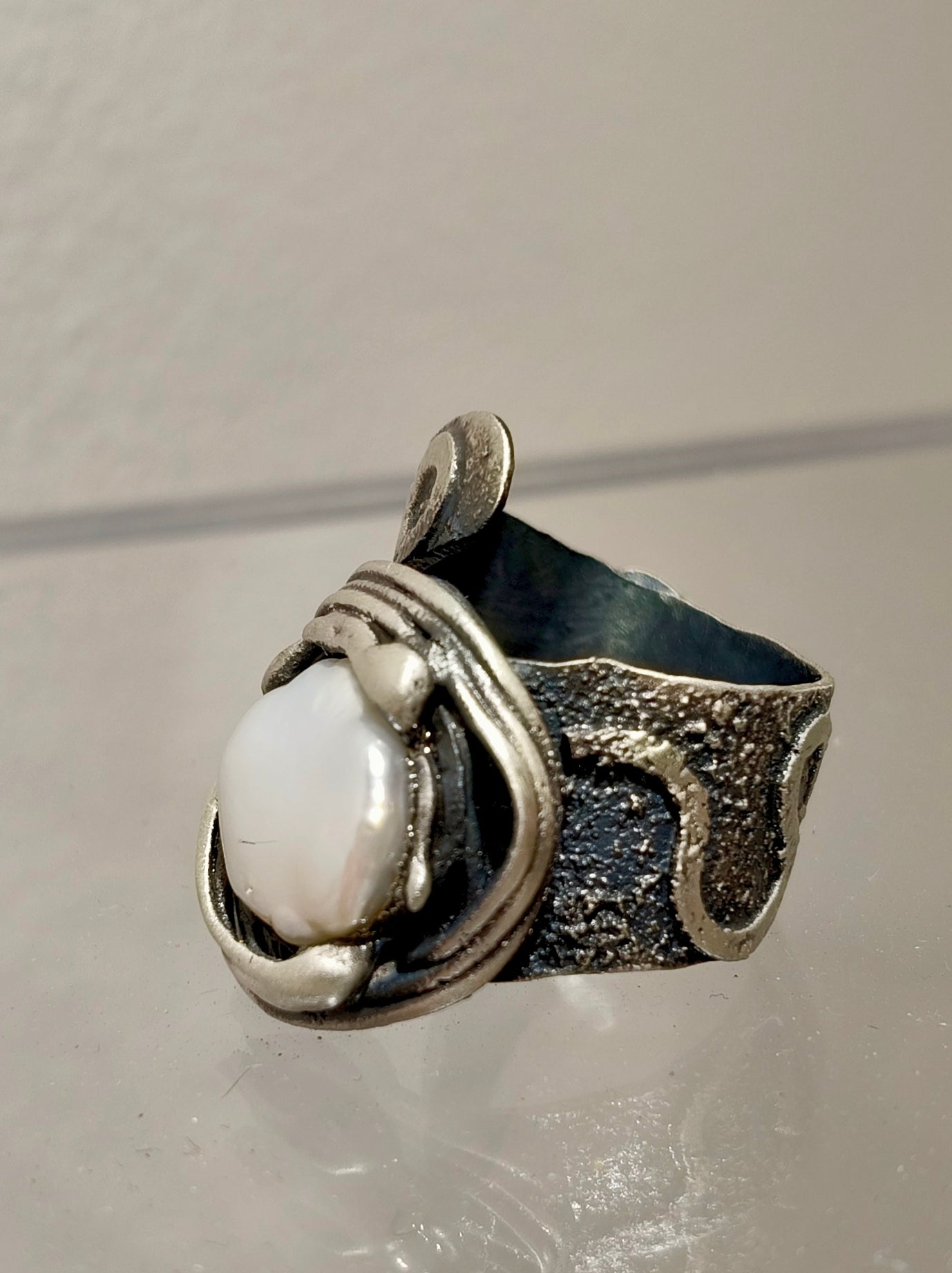 Anillo de plata artesanal con perla Keshi visto desde otro ángulo.